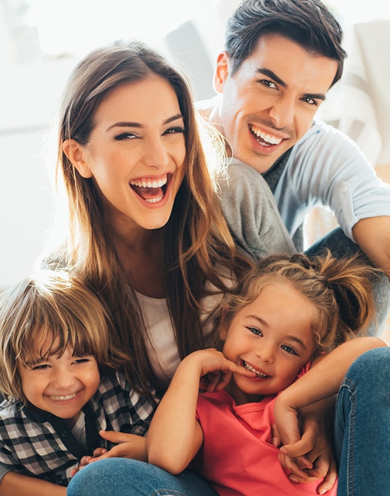 Mother father and children laughing together after visiting the dentist