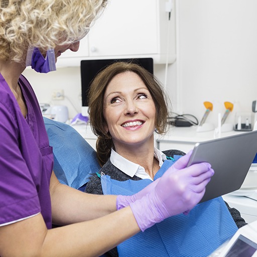 Dentist and patient examining x-rays on tablet computer