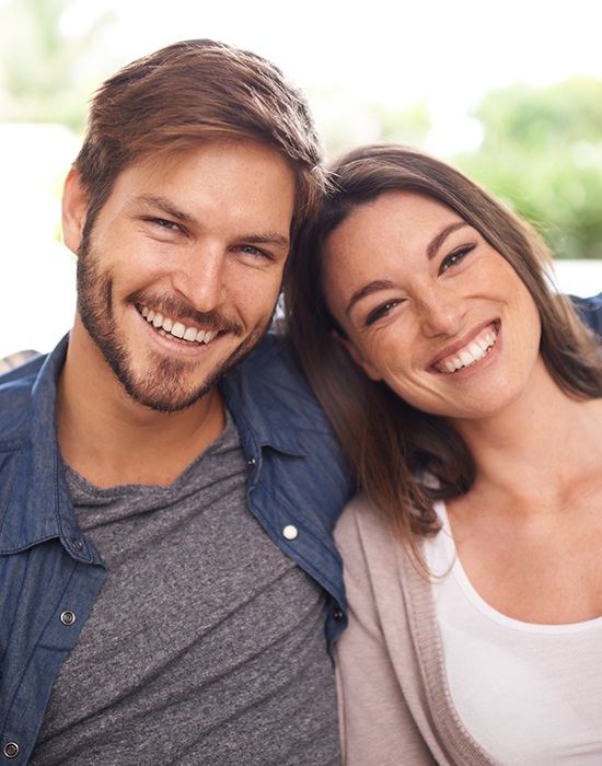 Man and woman sharing flawless smiles after cosmetic dentistry