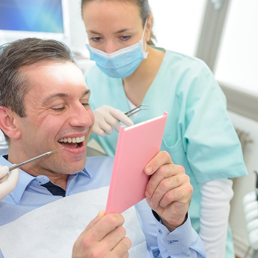 a patient admiring his new dental crown