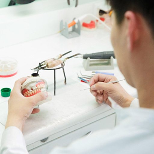 A technician making dentures in a lab