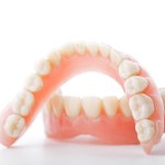 Closeup of full dentures in Fort Worth on a white background