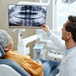 Smiling dentist reviewing X-rays with patient