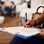 Closeup of patient filling out dental insurance information