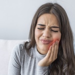 Woman with toothache holding cheek