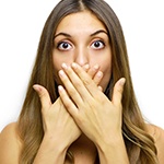Woman with knocked out tooth covering her mouth