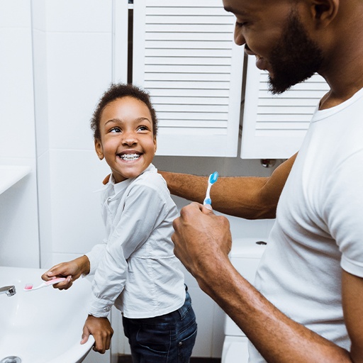 Father and child brushing teeth to prevent dental emergencies