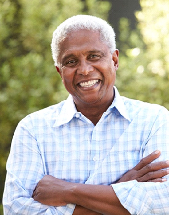 Senior man smiling with implant dentures in Fort Worth, TX