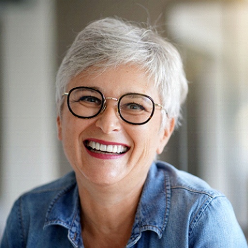 Senior woman with glasses and implant dentures in Fort Worth, TX