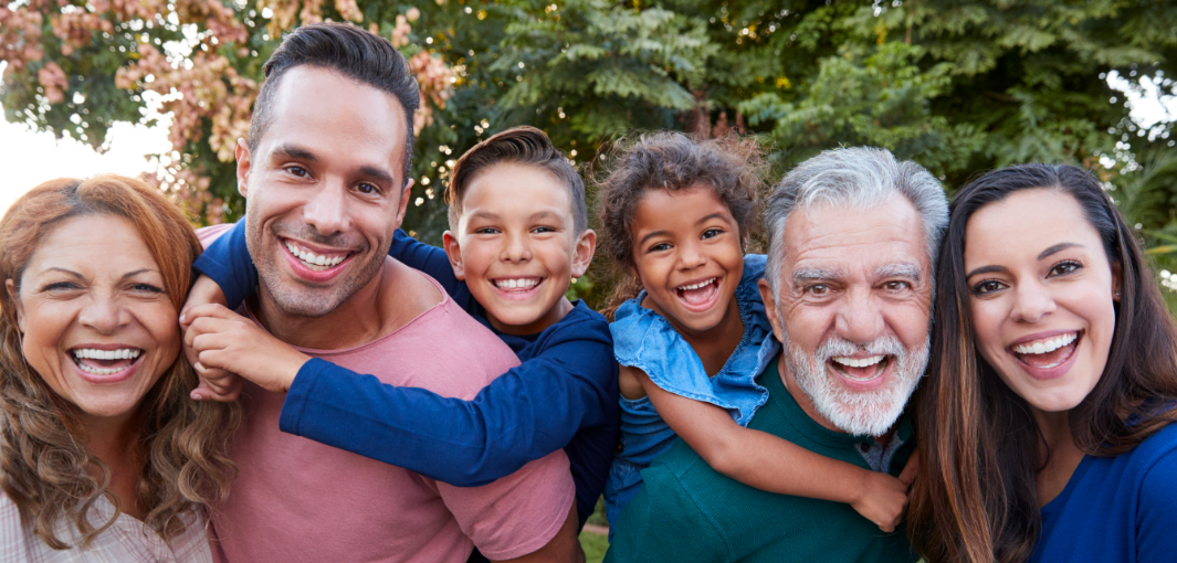 Three generations of family smiling outdoors