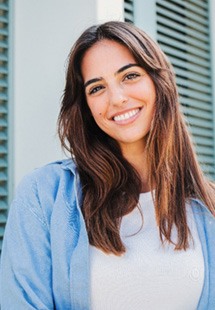 Woman with white teeth smiling while standing outside