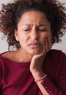 Woman with toothache sitting on couch at home