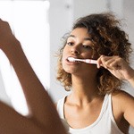 Patient in Fort Worth brushing their dental implants