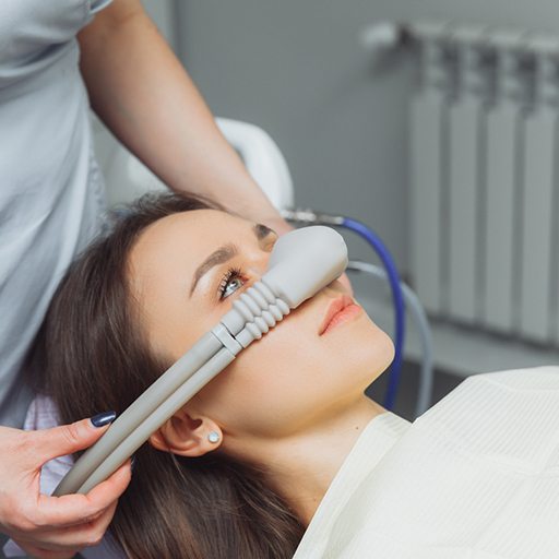 Dentist placing nitrous oxide mask over patient’s nose
