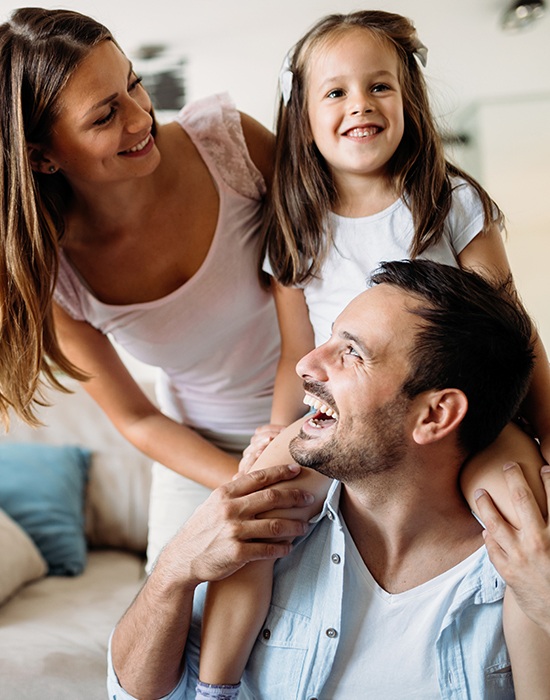 Mother father and child with healthy smiles after preventive dentistry