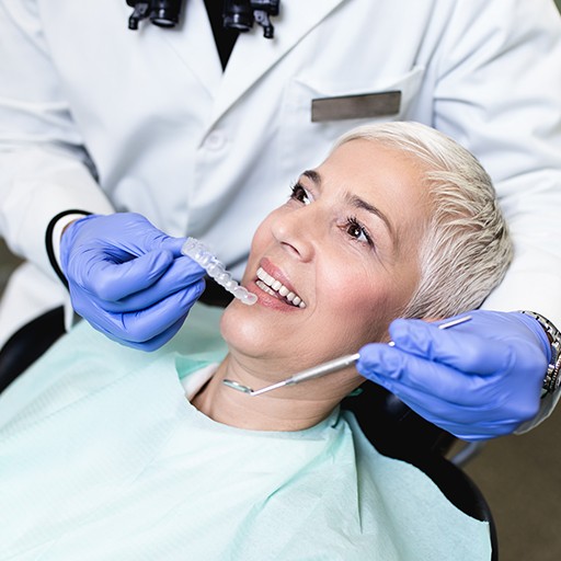 Dentist placing custom nightguard for teeth grinding