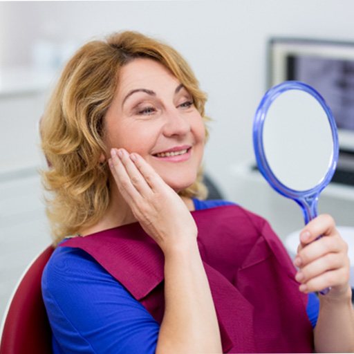 dental patient seeing her new smile in a mirror