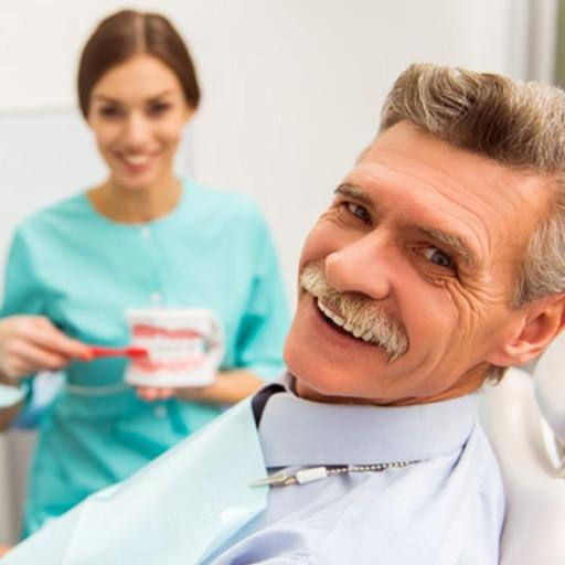 senior man smiling in dental chair