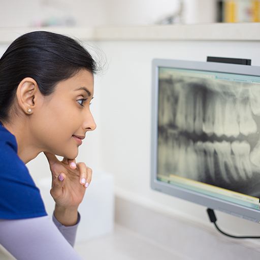 Dental team member examining digital x-rays