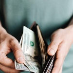 Man counting cash in wallet