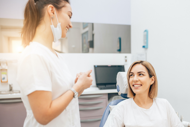 Woman in dental chair talking to dentist