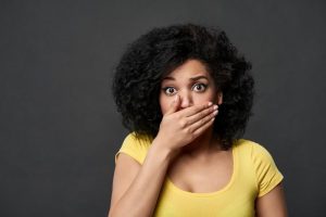 concerned woman covering her mouth before seeing Fort Worth cosmetic dentist