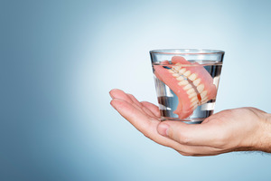 dentures being soaked in a glass